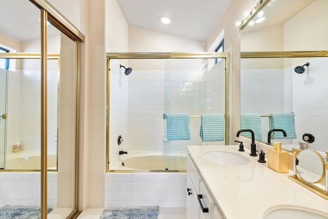 bathroom with lofted ceiling, vanity, and shower / bath combination with glass door