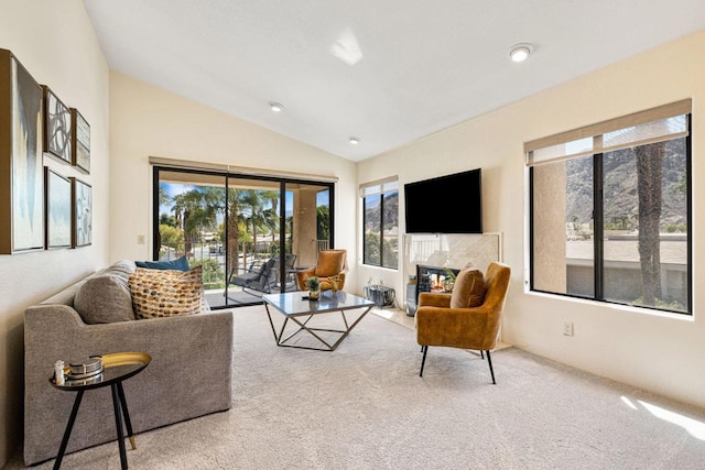 carpeted living room with a premium fireplace and lofted ceiling