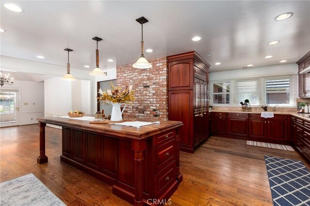 kitchen featuring pendant lighting, dark hardwood / wood-style flooring, and a notable chandelier