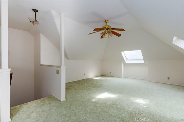 bonus room with light carpet, vaulted ceiling with skylight, and ceiling fan