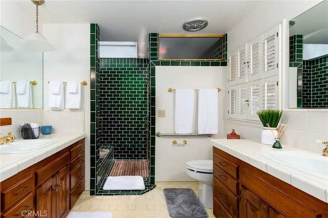 bathroom with toilet, tiled shower, decorative backsplash, vanity, and tile walls