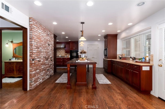 kitchen with backsplash, dark hardwood / wood-style flooring, decorative light fixtures, and sink