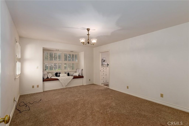 spare room with carpet, a healthy amount of sunlight, and an inviting chandelier