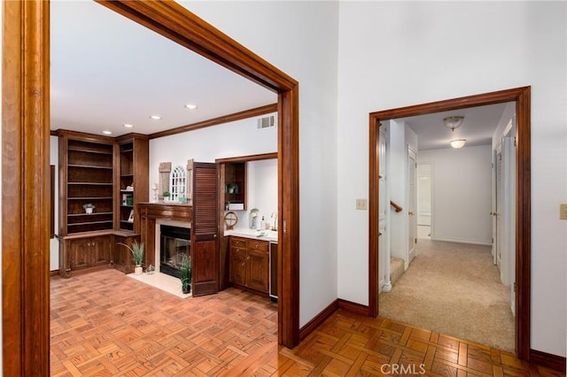 hall with light parquet floors and ornamental molding