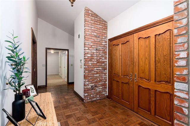 corridor featuring dark parquet flooring and high vaulted ceiling