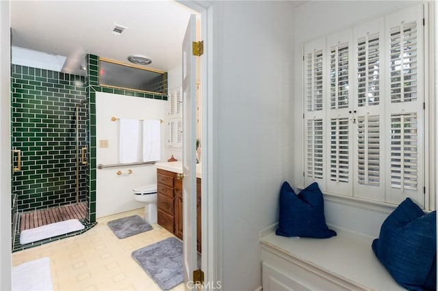 bathroom featuring tiled shower, vanity, and toilet