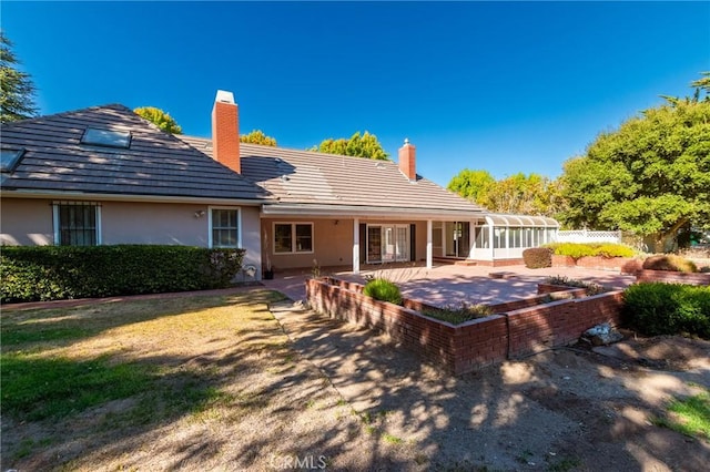 back of house with a sunroom and a patio