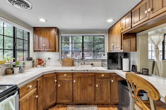 kitchen featuring tile counters, sink, and plenty of natural light