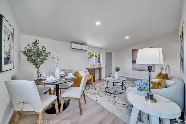 dining area with light hardwood / wood-style floors, lofted ceiling, and a wall mounted air conditioner