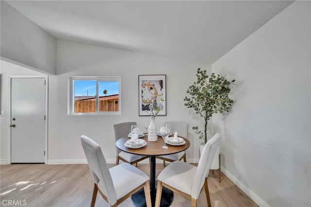 dining room featuring light hardwood / wood-style floors and vaulted ceiling