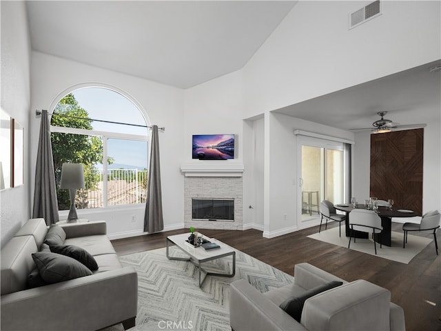 living room featuring ceiling fan, a fireplace, and dark hardwood / wood-style floors