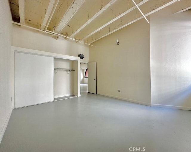 unfurnished bedroom featuring concrete flooring and a closet