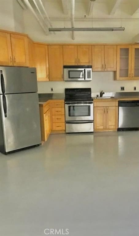 kitchen with appliances with stainless steel finishes, light brown cabinetry, and sink