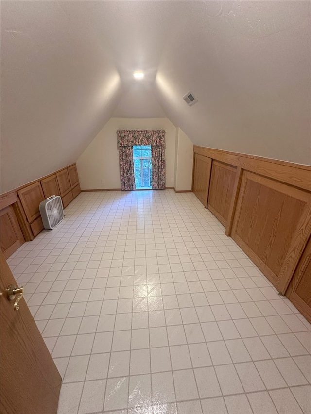 bonus room featuring lofted ceiling and light tile patterned flooring