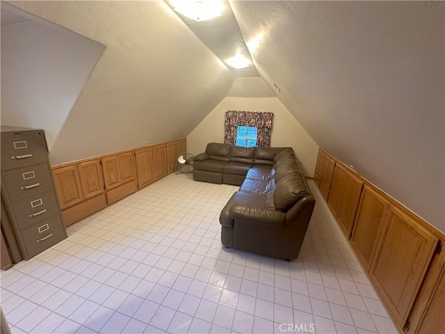 interior space with vaulted ceiling and light tile patterned flooring