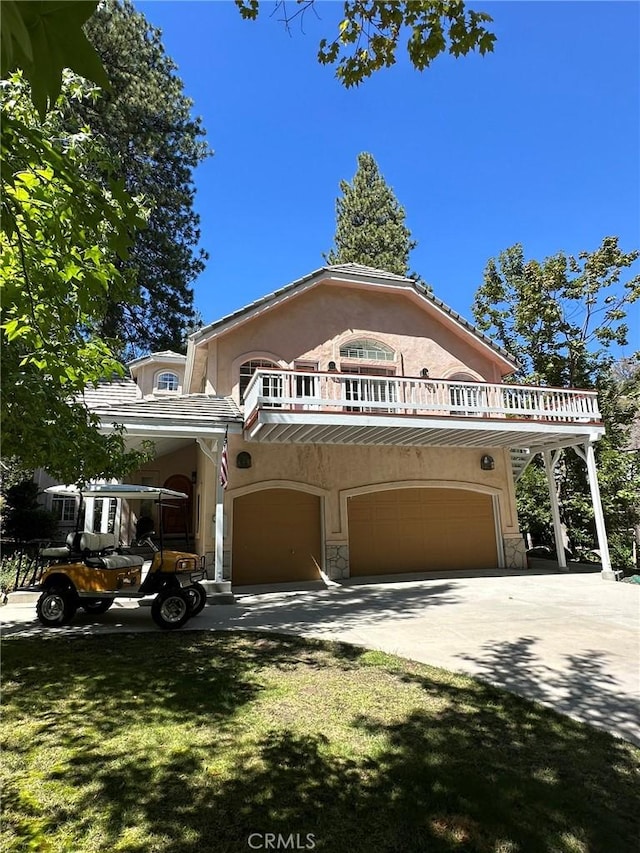 view of front facade with a garage, a front yard, and a balcony