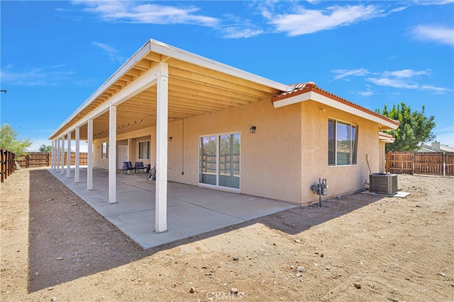 rear view of property with central AC unit and a patio area