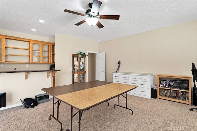 office space featuring light carpet, a textured ceiling, and ceiling fan