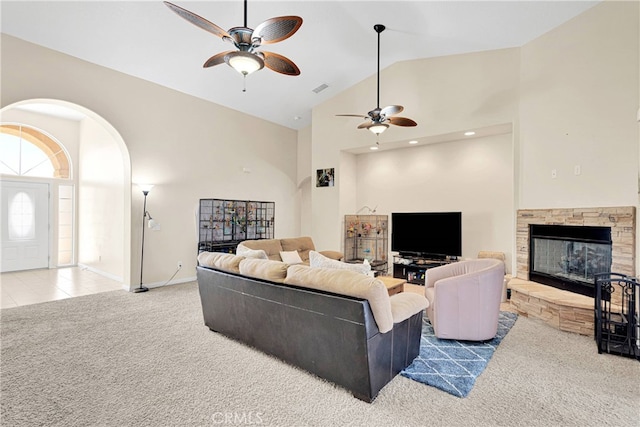 living room with carpet floors, a fireplace, high vaulted ceiling, and ceiling fan