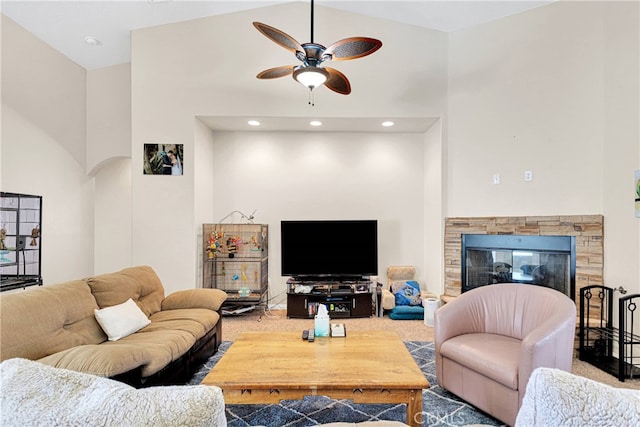 living room featuring high vaulted ceiling, carpet, ceiling fan, and a fireplace