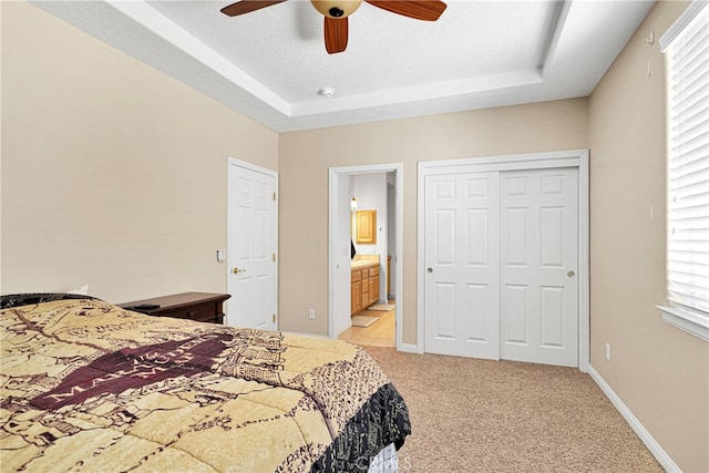 bedroom featuring ceiling fan, a textured ceiling, light carpet, and ensuite bathroom