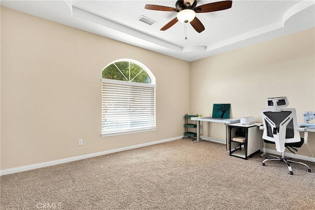 office area with light carpet, a textured ceiling, a raised ceiling, and ceiling fan