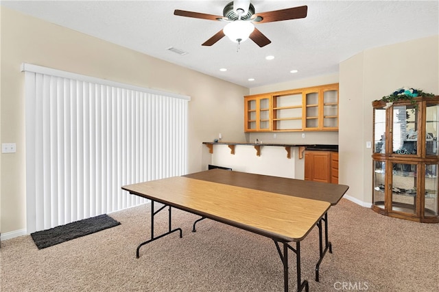 office area with a textured ceiling, ceiling fan, and light colored carpet