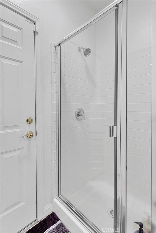 bathroom featuring a shower with door