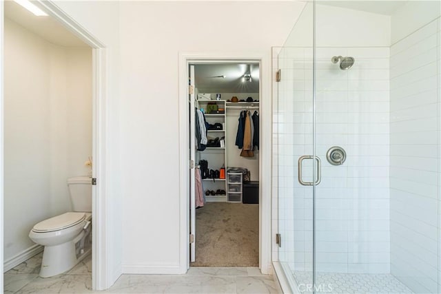 full bathroom featuring baseboards, a shower stall, marble finish floor, toilet, and a walk in closet