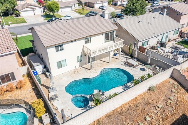 view of swimming pool with a patio area, a residential view, a fenced in pool, a fenced backyard, and an in ground hot tub