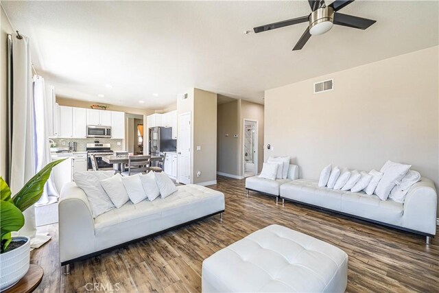 living area with recessed lighting, a ceiling fan, visible vents, baseboards, and wood finished floors