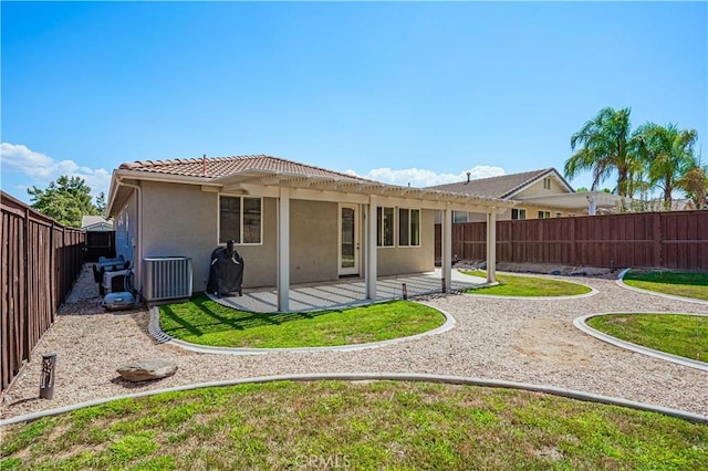 rear view of property with a lawn, a patio area, and central air condition unit