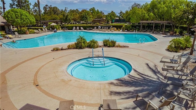 view of swimming pool featuring a community hot tub and a patio