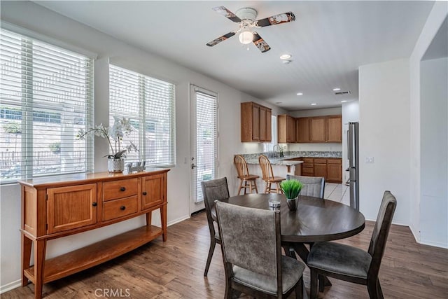 dining area with ceiling fan, hardwood / wood-style floors, and sink