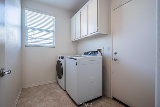 washroom with washer and dryer and cabinets