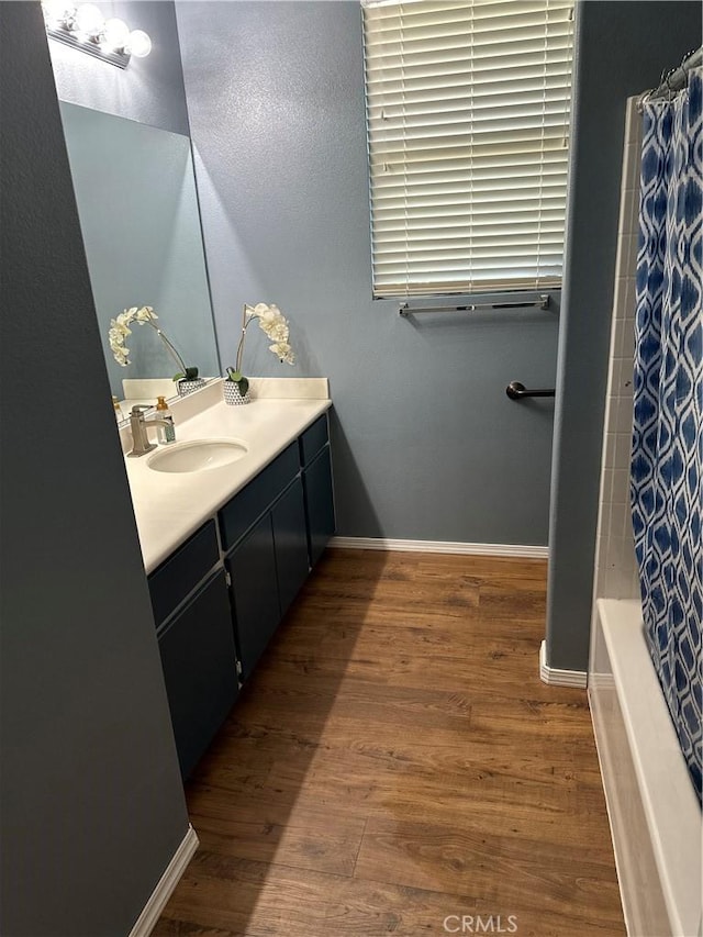 bathroom featuring hardwood / wood-style floors, vanity, and shower / tub combo with curtain