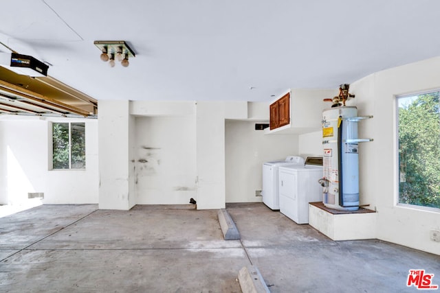 garage with strapped water heater and washer and clothes dryer