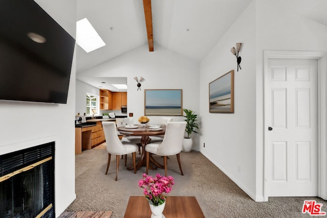 carpeted dining room with vaulted ceiling with skylight