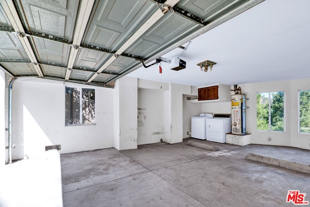 garage featuring washer and dryer, a garage door opener, and water heater