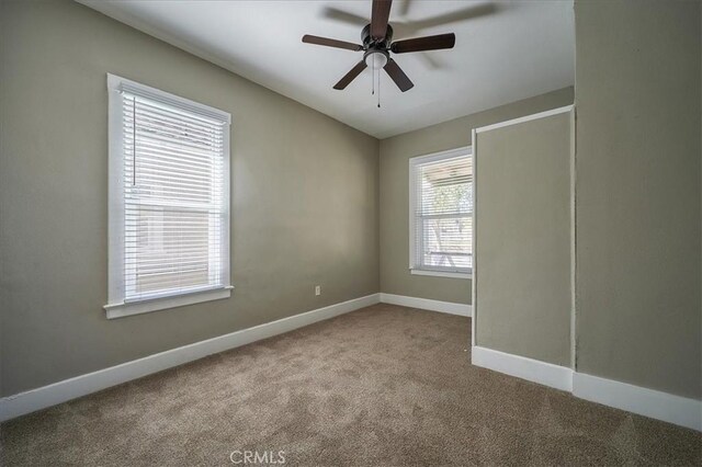 unfurnished room with light carpet, a wealth of natural light, and ceiling fan