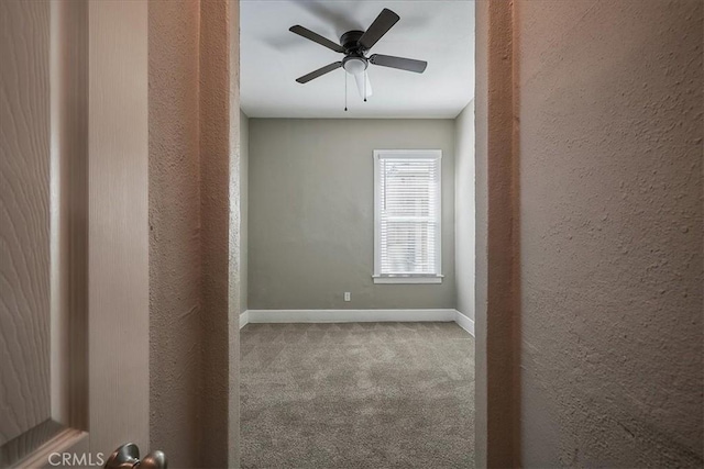 carpeted spare room with ceiling fan