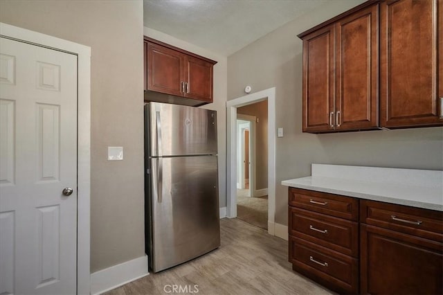 kitchen with stainless steel fridge and light hardwood / wood-style flooring