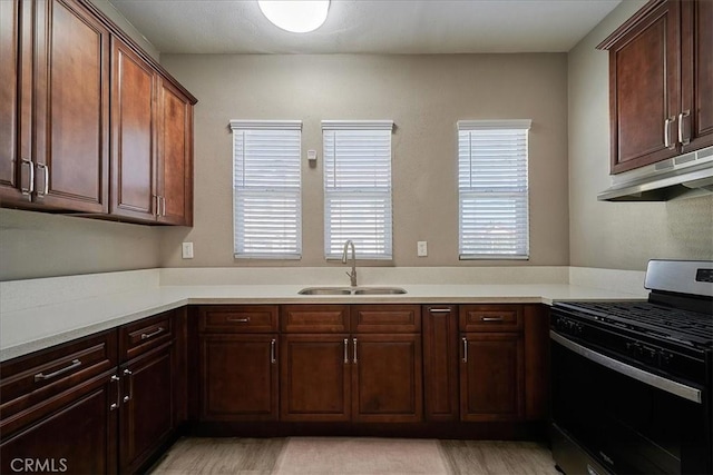 kitchen featuring gas stove, sink, and light hardwood / wood-style floors