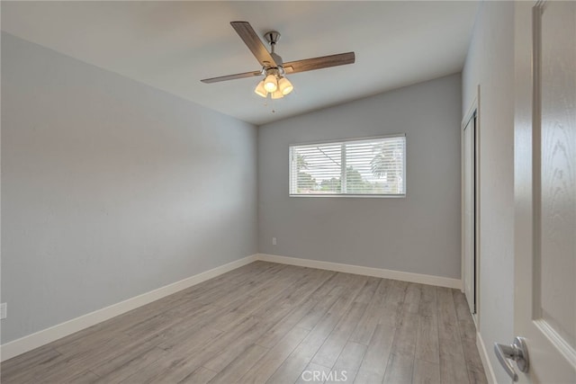 empty room featuring ceiling fan, light wood-type flooring, and vaulted ceiling