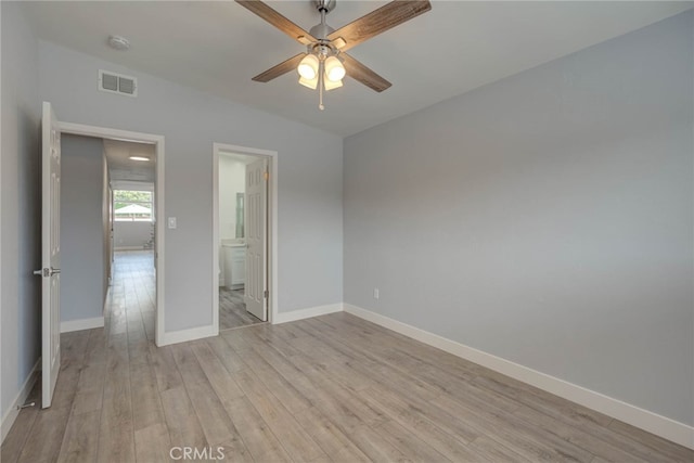 unfurnished bedroom featuring connected bathroom, light hardwood / wood-style floors, lofted ceiling, and ceiling fan