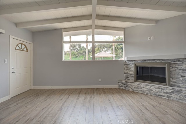 unfurnished living room featuring light hardwood / wood-style floors, lofted ceiling with beams, and a fireplace