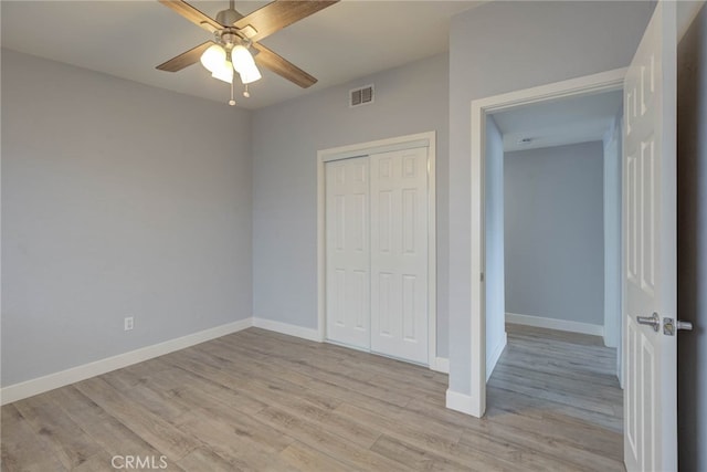 unfurnished bedroom featuring light hardwood / wood-style flooring, a closet, and ceiling fan