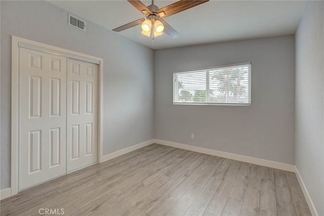 unfurnished bedroom with a closet, light hardwood / wood-style floors, and ceiling fan