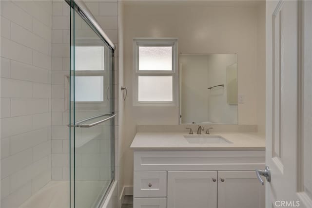 bathroom featuring vanity and bath / shower combo with glass door