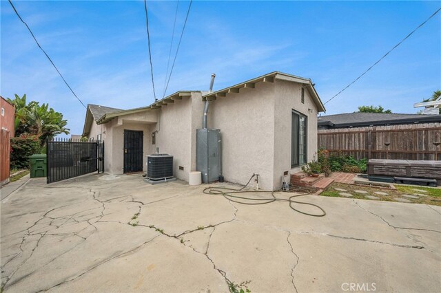 3927 W 58th Pl, Los Angeles, CA 90043 - rear view of property with stucco siding, central AC unit, a patio area, and a gate
